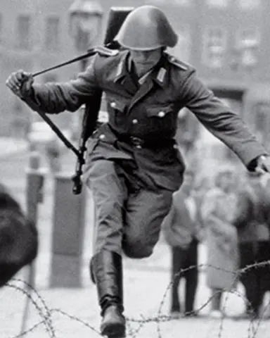 Schumann leaping over barbed wire into West Berlin on 15 August 1961.
