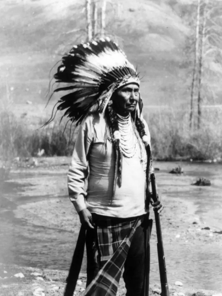 Chief Joseph standing in a feather headdress