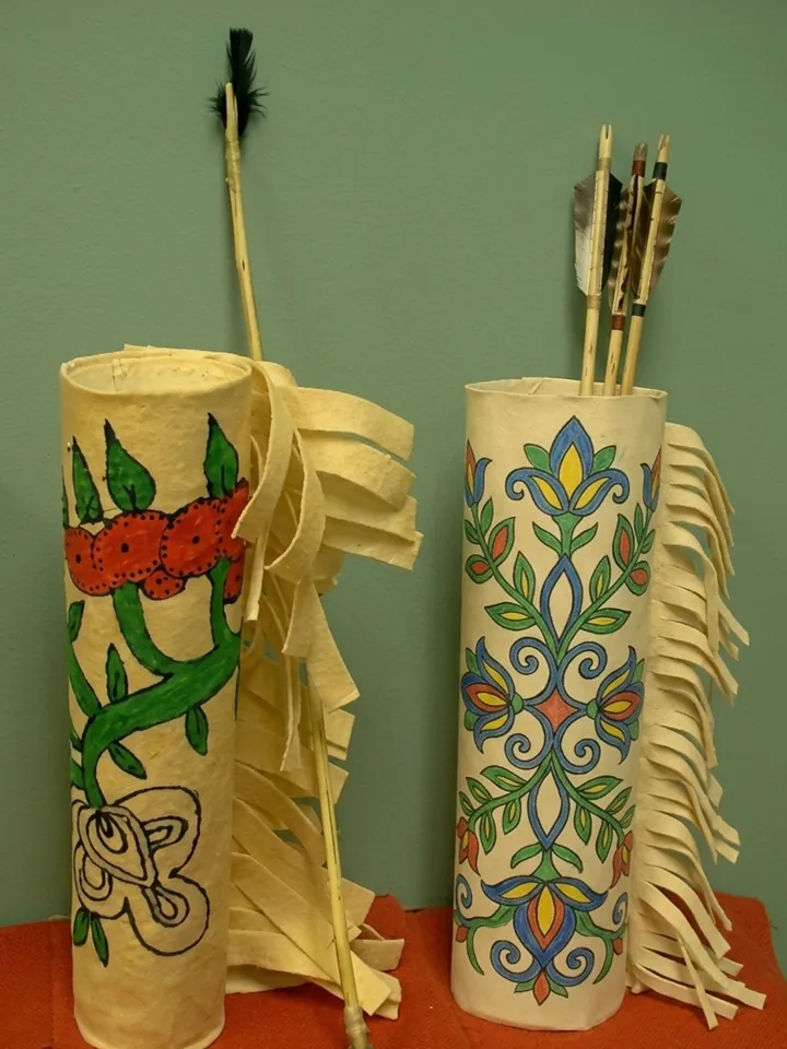 Two student-made quivers decorated with painted designs, holding arrows