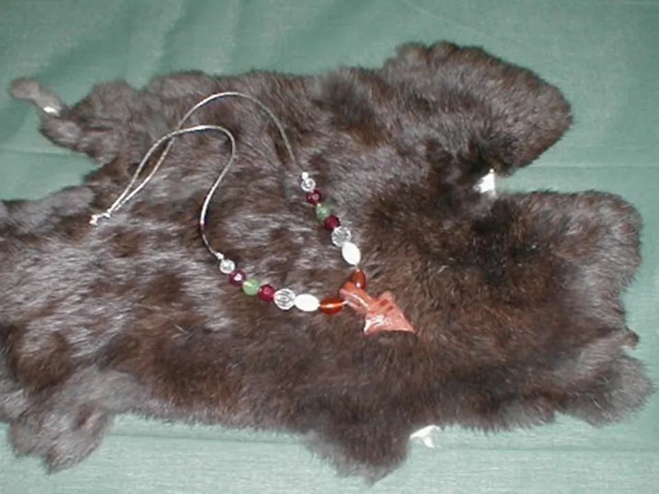 A student-made necklace displayed on a fur hide