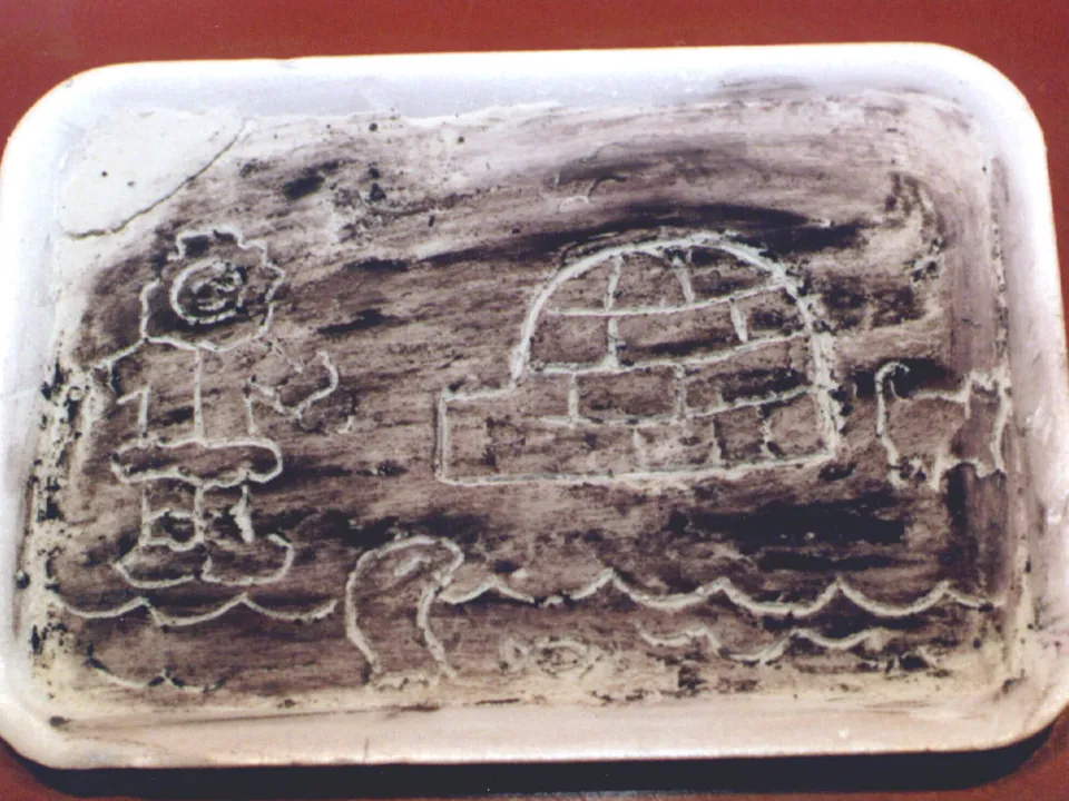 A student engraving of an igloo and people scratched into a white surface filled with black