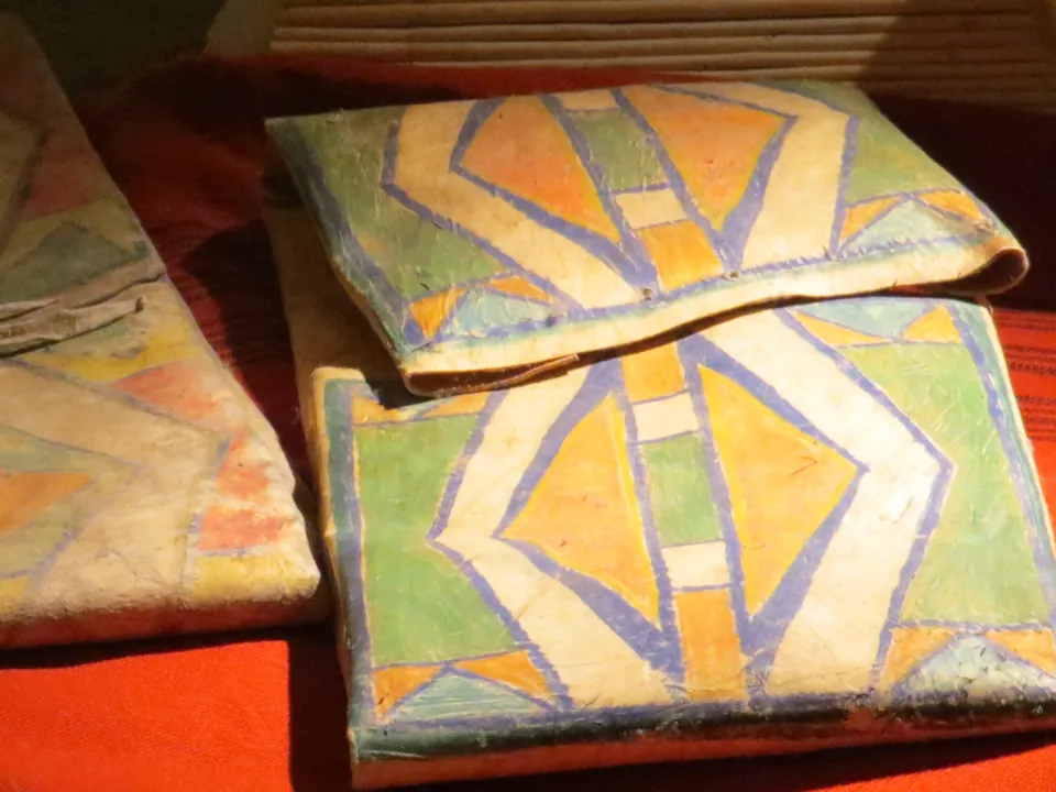 Folded rawhide cases painted with bold geometric designs
