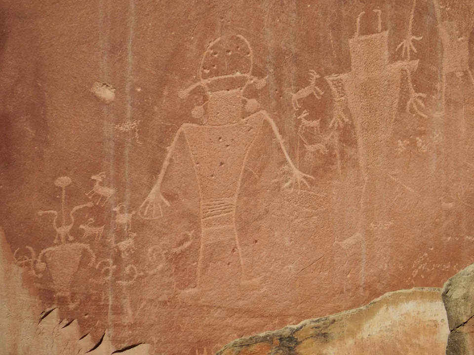 Human-like figures pecked into a red rock wall