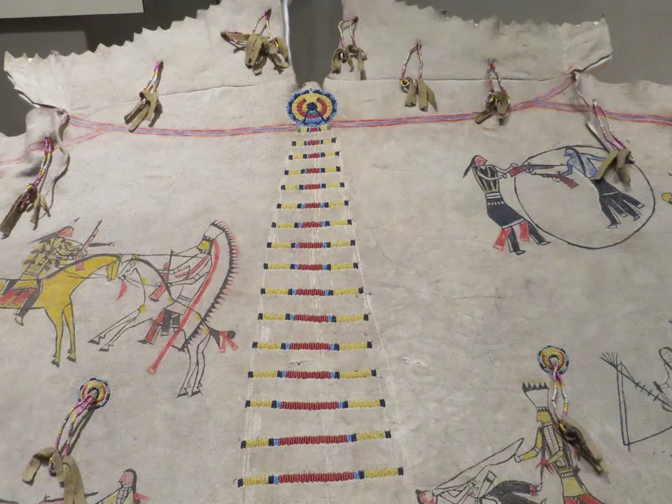 A painted hide tipi cover with pictures of horses and riders