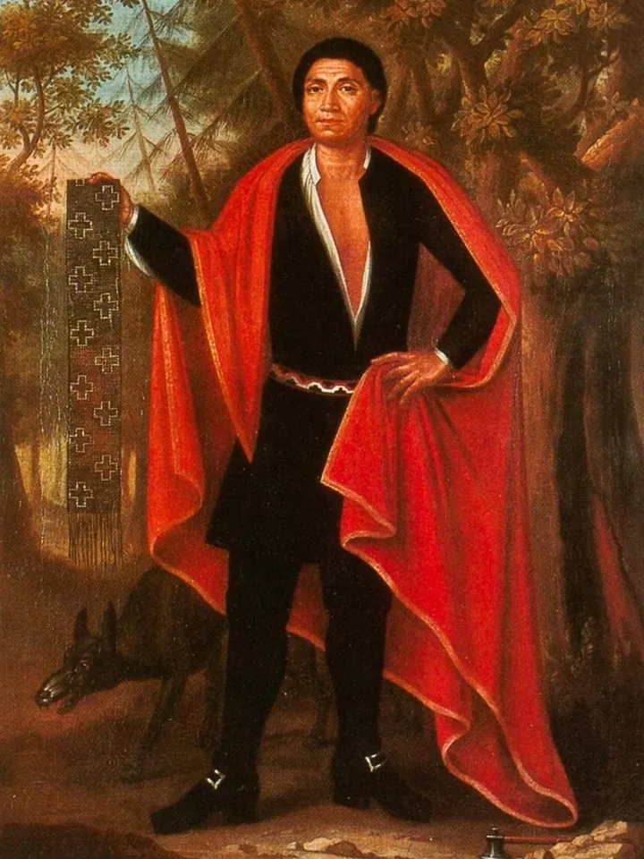 Portrait of a Mohawk leader in a red cloak, holding a wampum belt