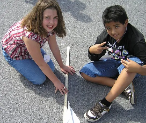 Students flying paper airplanes in the hallway