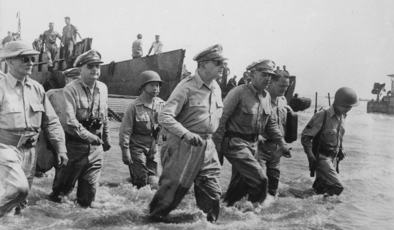 General Douglas MacArthur wades ashore during initial landings at Leyte, Philippine Islands